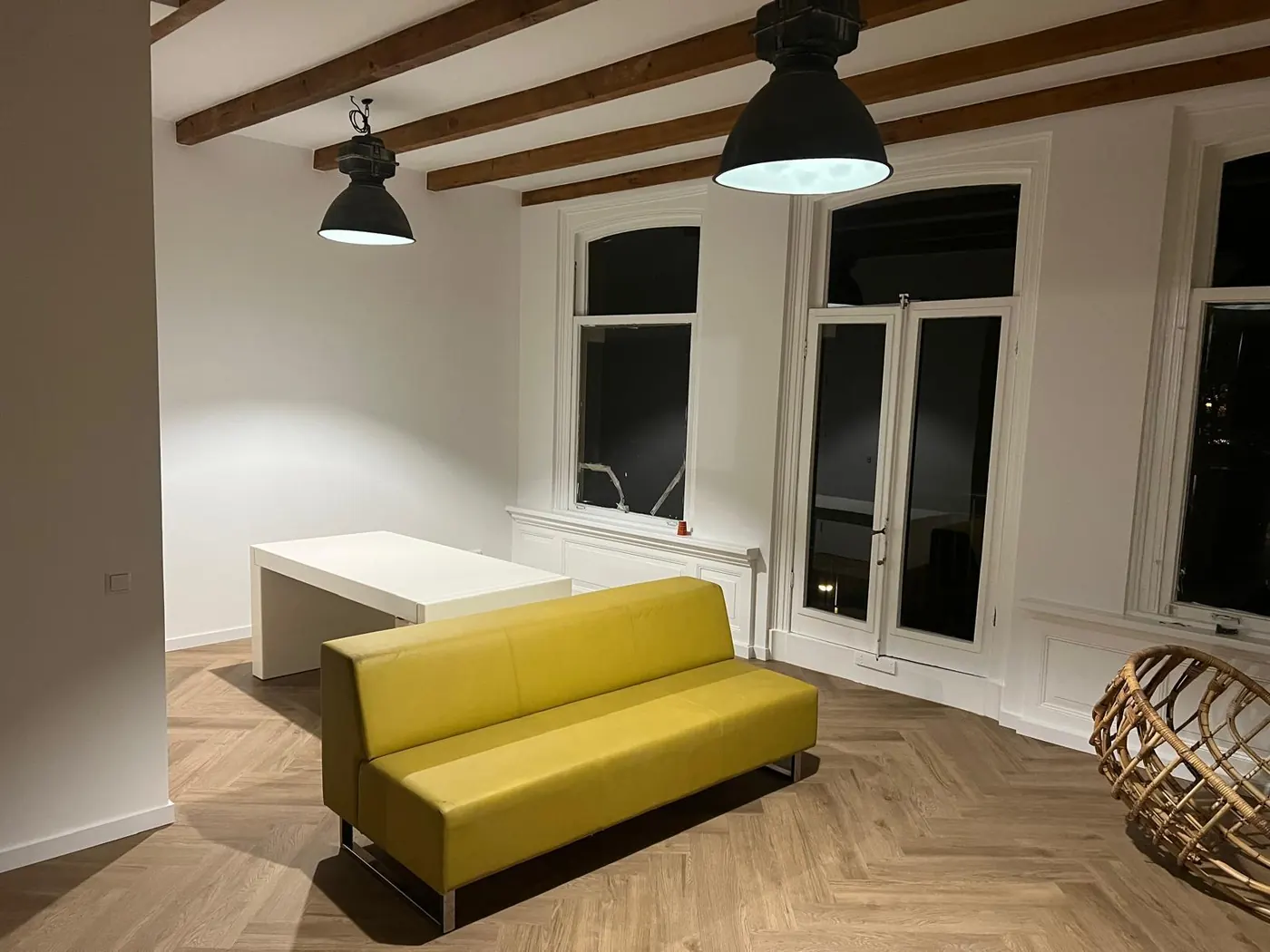 Woonkamer met balkenplafond en visgraatvloer